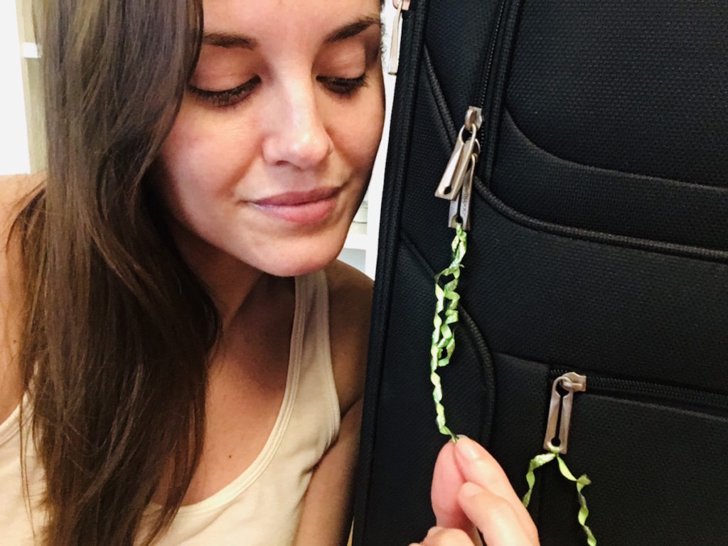 Chrissy showing you the ribbons she tied on her suitcase zippers.